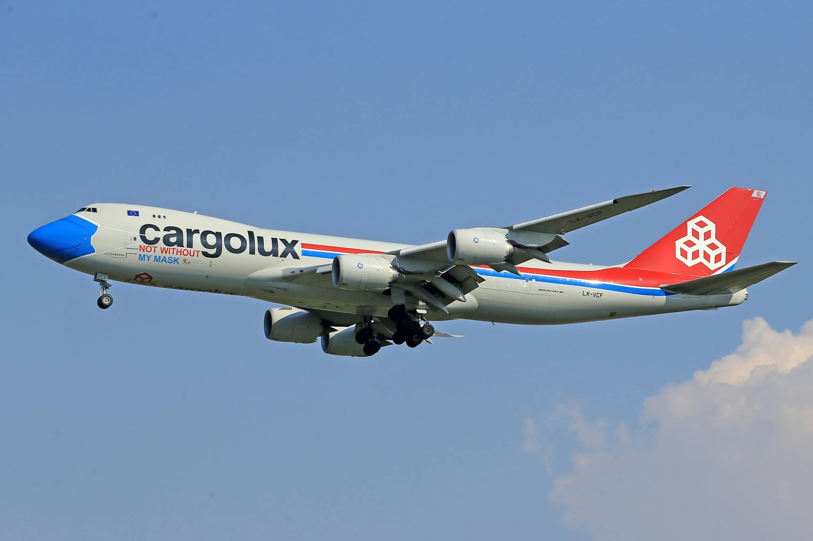 Cargolux cargo plane flying amidst a clear blue sky, highlighting air travel and logistics.